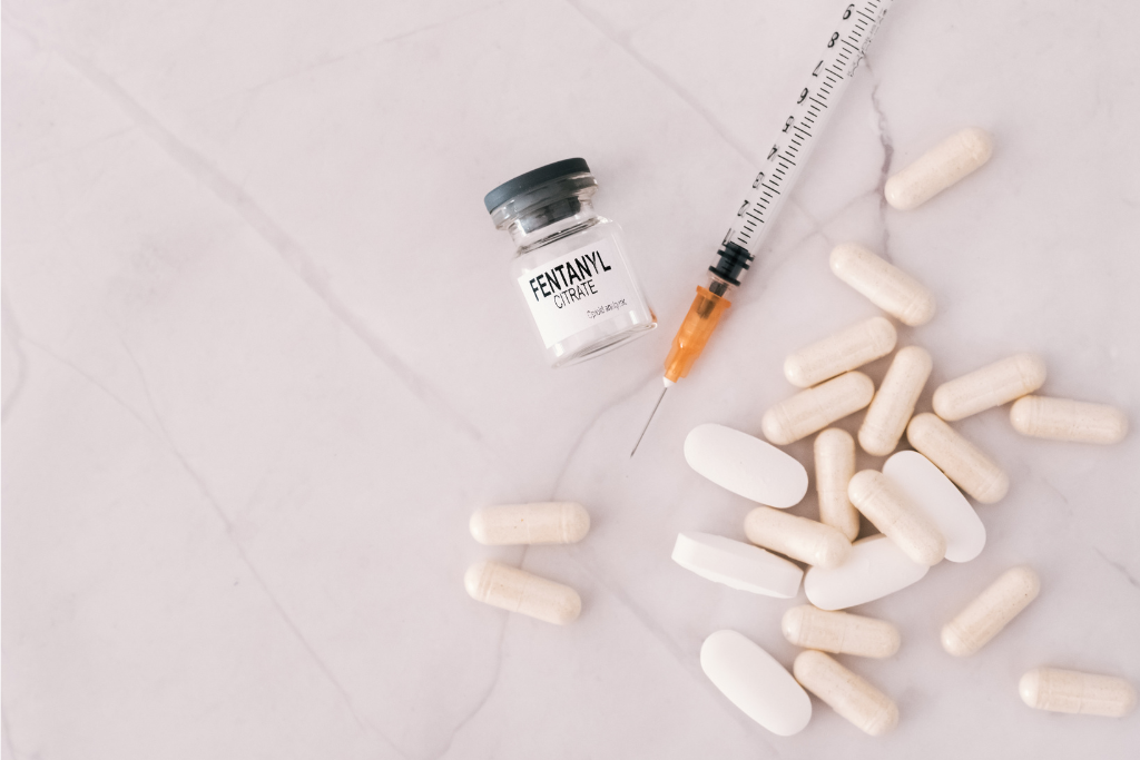 Image of a syringe, a vial labeled 'Fentanyl Citrate,' and pills scattered on a light background, representing Fentanyl rehab in Thousand Oaks, CA.