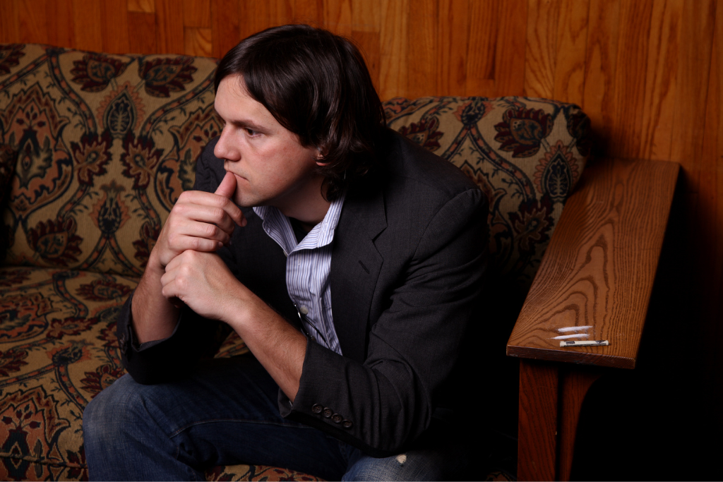 Man reflecting in a room, considering cocaine rehab in Thousand Oaks. The image depicts the struggle with addiction and the need for recovery.