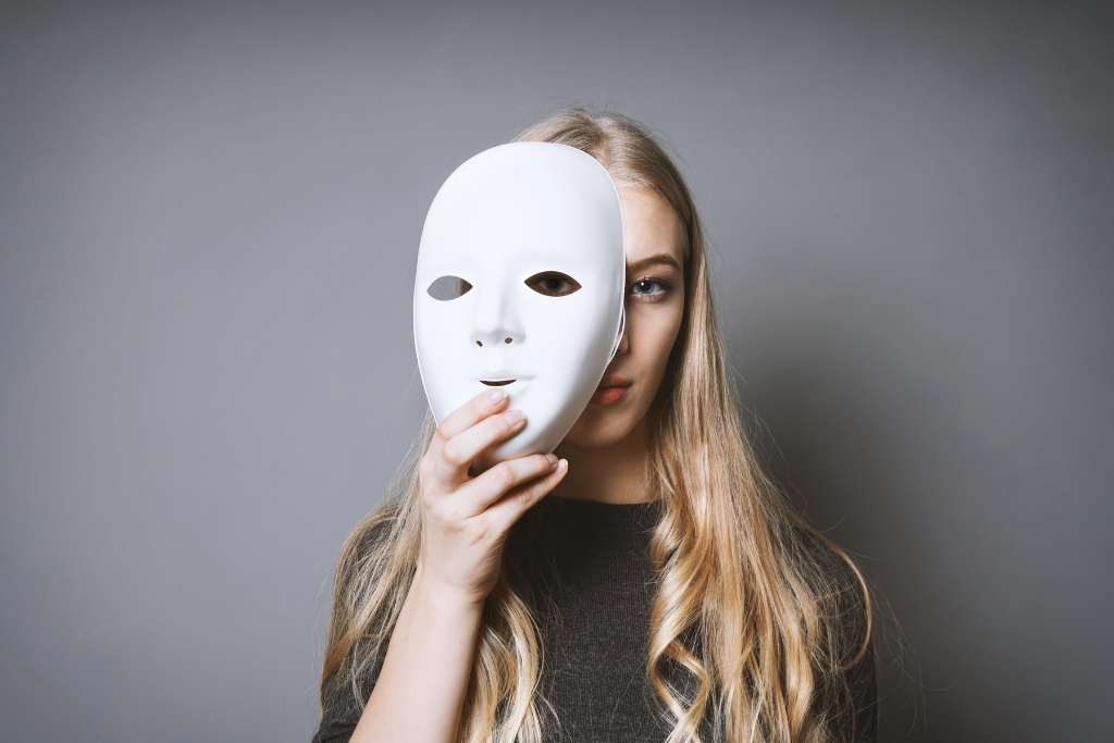 An image of a person holding a mask in front of their face, symbolizing the hidden symptoms of bipolar disorder. This image emphasizes the support available through bipolar treatment in Thousand Oaks, CA.