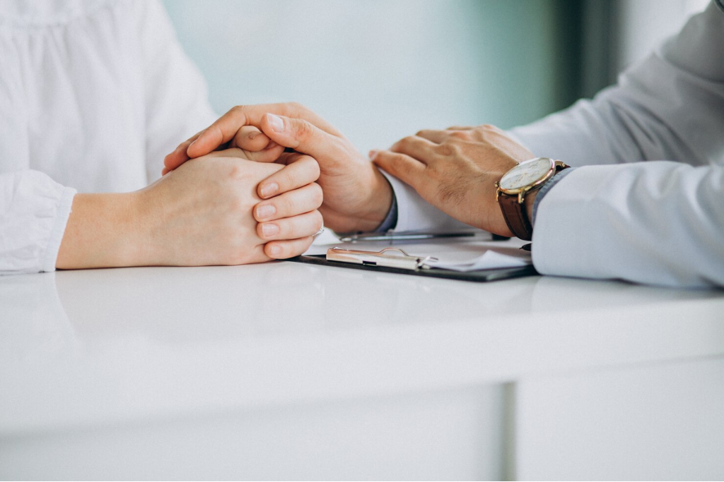 A doctor compassionately holding a patient's hands over a desk, highlighting personalized care in outpatient rehab in Thousand Oaks, CA.