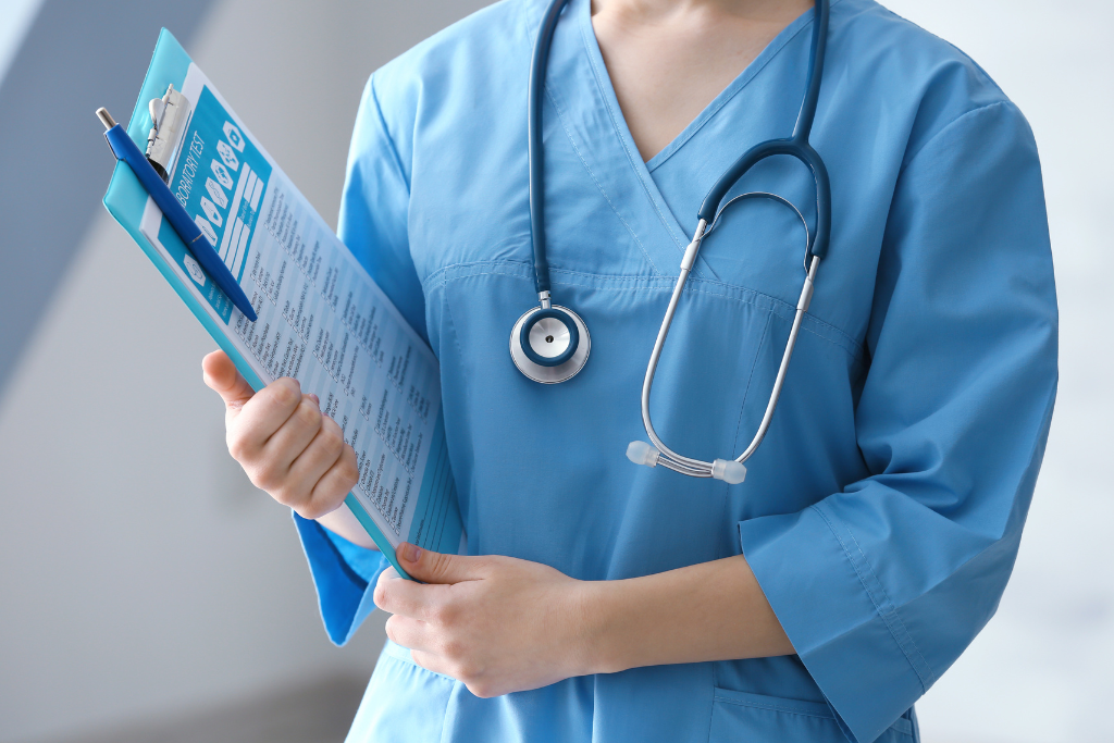 A healthcare professional in blue scrubs holds a clipboard, symbolizing organized patient care within the MAT program Thousand Oaks CA.